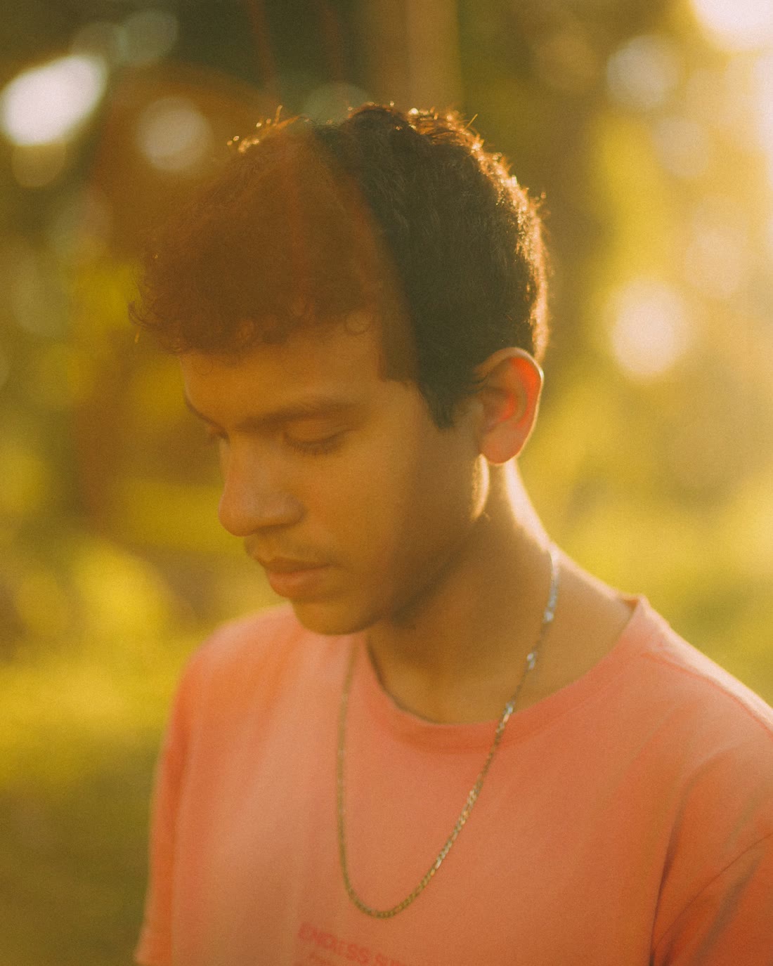 Teenage boy looking down in warm sunlight