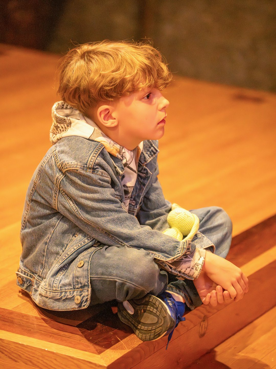 Young boy sitting on a wooden floor