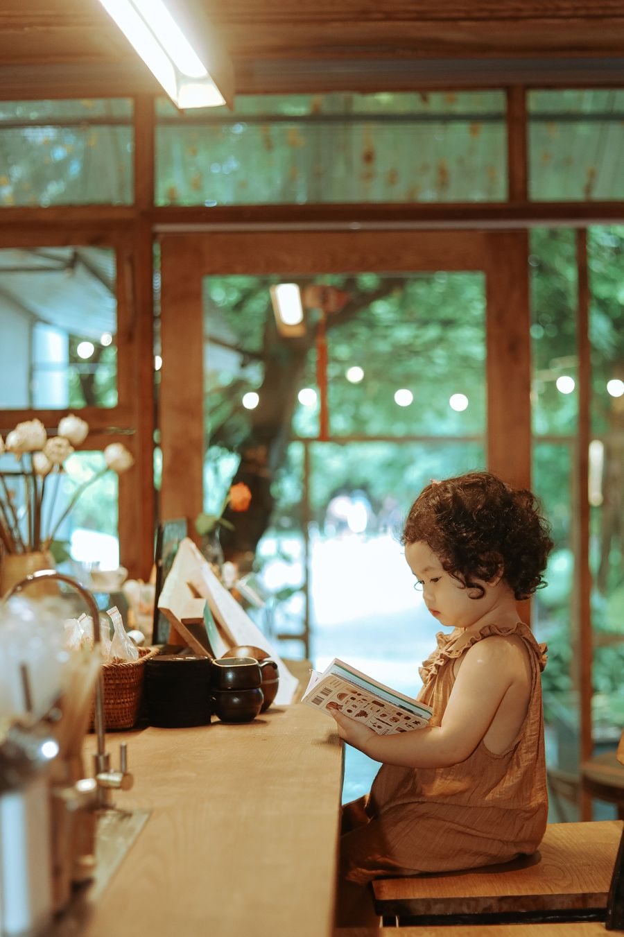 Young child reading a book at a counter