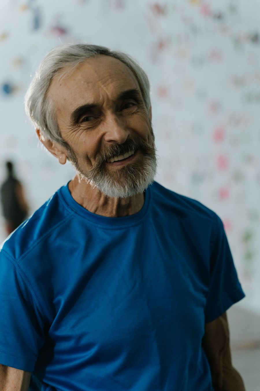 Older man with a gray beard smiling