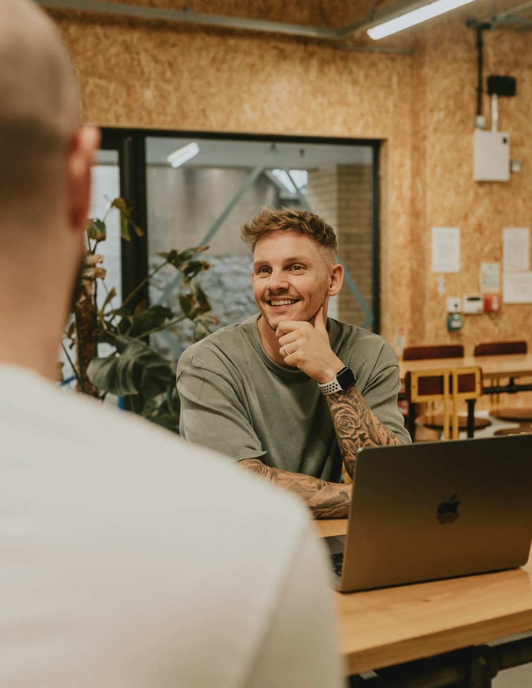 Man smiling across a table in conversation